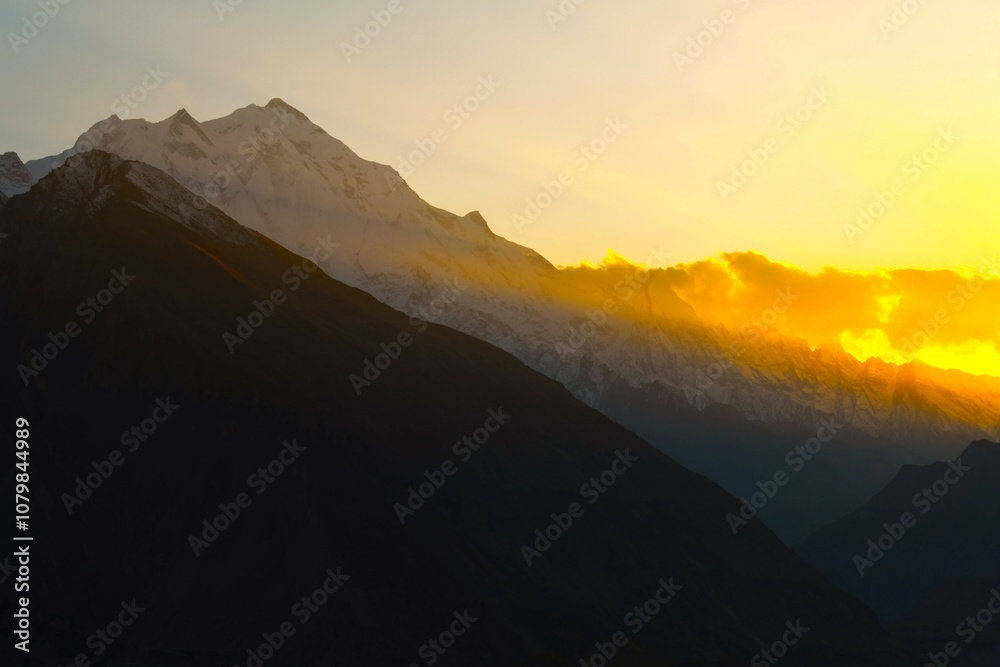 Sunset scenery of Rakaposhi (7788 m, Shining Wall, Dumani or Mother of Mist) - an extremely broad mountain situated in the Nagar and Bagrote Valley within the Karakoram range (Pakistan) Sunset scenery of Rakaposhi (7788 m, Shining Wall, Dumani or Mother of Mist) - an extremely broad mountain situated in the Nagar and Bagrote Valley within the Karakoram range (Pakistan)