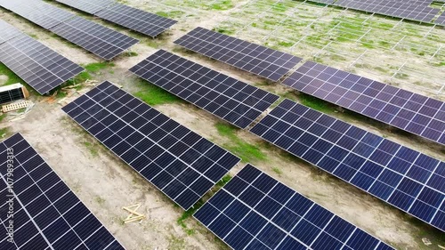 Aerial low dynamic establishing shot of clean new solar panels at solar park photo