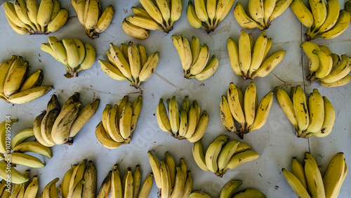 Top down view of bunches of locally grown yellow bananas on fruit and vegetable market stall on tropical island of Mo'orea in French Polynesia, South Pacific photo