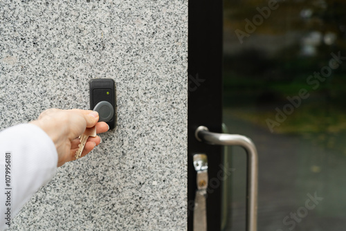 Woman's hand opening entrance door with fob
