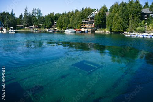 Fotografie Sunken shipwreck with cottages in the background