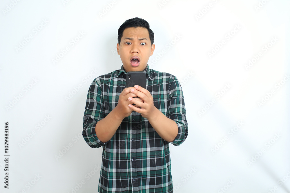 shocked asian man looking at smartphone show confused expression isolated on white background shocked asian man looking at smartphone show confused expression isolated on white background