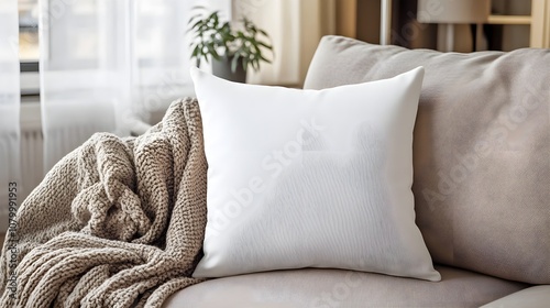 A plain throw pillow on a cozy couch, in a stylish living room with blankets and decor, ideal for home decor or quote mockups.