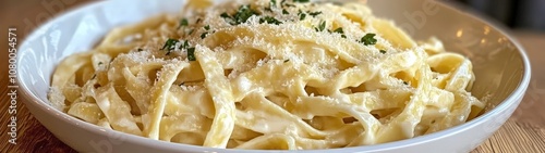 Delicious creamy fettuccine pasta topped with Parmesan cheese and parsley, perfect for a gourmet meal or dinner.