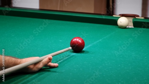 Russian billiards on a green table. American billiard. The player hits the red ball with a cue and rolling a white ball into the pocket. Successful shot. Pastime at home playing sport game hobby photo