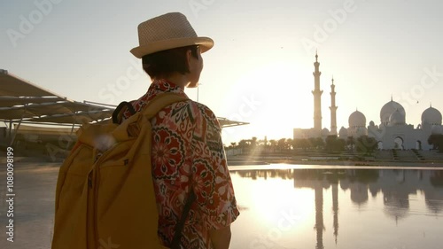 female tourist enjoys serene moment while admiring stunning view of the Sheikh Zayed Mosque in Abu Dhabi. grand architecture and peaceful surroundings, view from park Wahat Al Karama photo