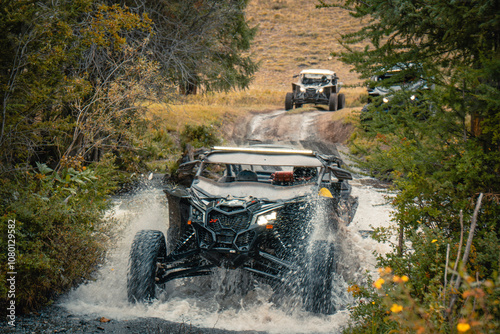 Buggy trip in a Altai desert. Mountain landscape with hills and beautiful blue sky with clouds in background. Off-road vehicles driving on a dust dirt road. Active leisure in Altai Republic.