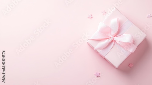 A pink box with a bow on top sits on a pink background