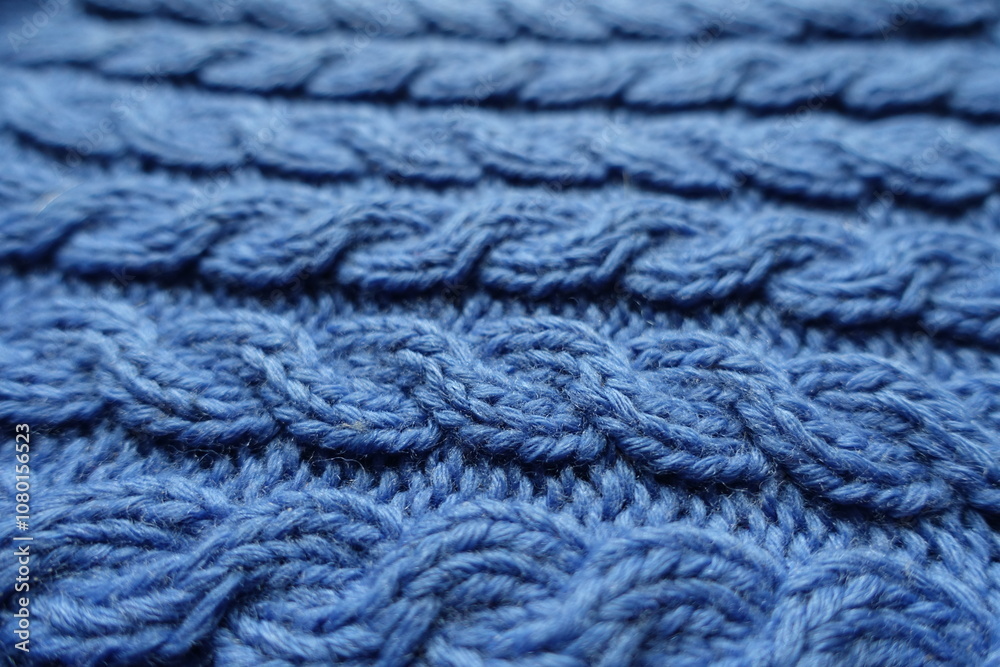 Close shot of handmade blue knitted fabric with cable braids Close shot of handmade blue knitted fabric with cable braids