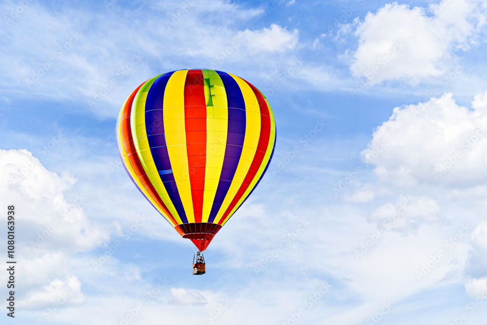 Fototapeta premium Colorful hot air balloon flying over blue sky with white clouds 