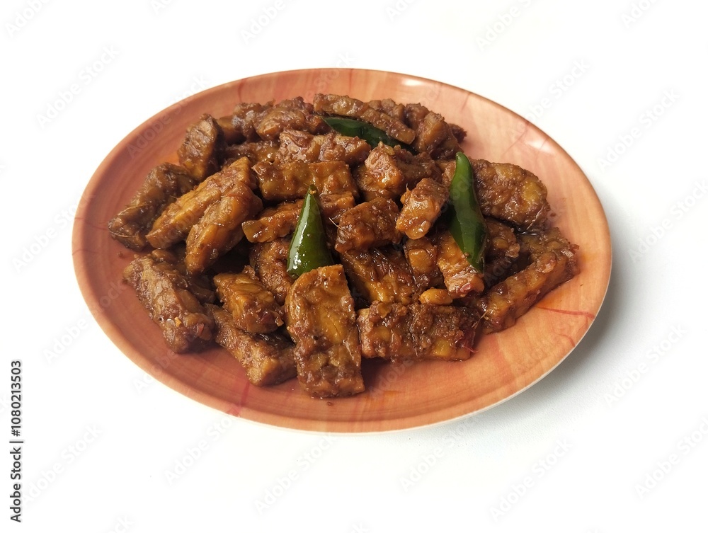 Oreg tempe or Indonesian food made from tempeh with soy sauce and spices on plate isolated on white background Oreg tempe or Indonesian food made from tempeh with soy sauce and spices on plate isolated on white background
