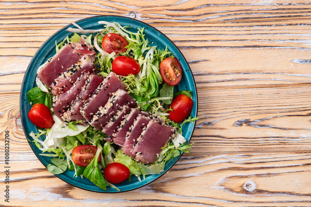 Salad with raw tuna , sesame and cherry tomatoes photography . Top view
