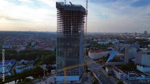 Construction site of the estrel tower in berlin 2024, with cranes and cityscape in the background. Nice aerial view flight tilt up drone photo