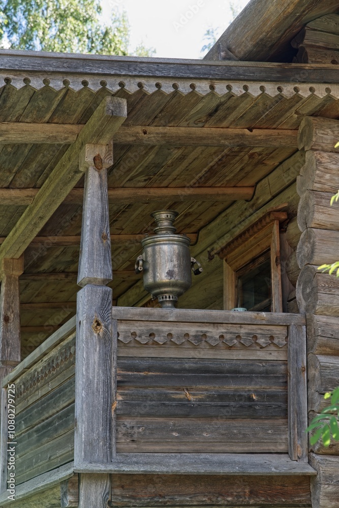 Obraz premium Mandrogi, Russia, July 11, 2024. An antique samovar on the porch of a wooden house. 