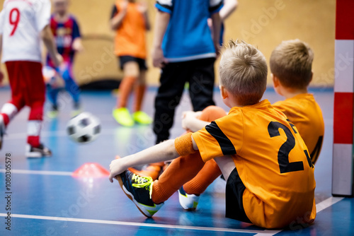 Fototapeta Naklejka Na Ścianę i Meble -  Children in Futsal Training. Indoor Soccer Class for Kids at School Sports Hall. Children Kicking Soccer Balls on Wooden Futsal Floor