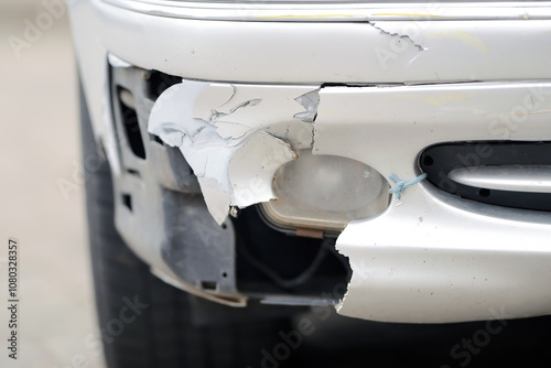Obraz na płótnie Damaged car front bumper after an accident on the road closeup. Car accident. Damaged bumper and fog light optics. Vehicle damage and accident. Front end crash. Selective focus w salonie