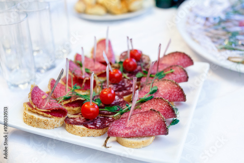 Canape with Italian salami, french baguette and ripe cherry tomatoes