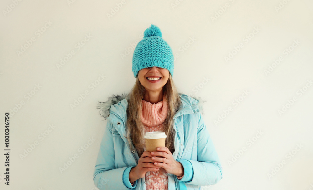 Happy smiling young woman with cup of coffee drink in blue winter hat having fun on white background Happy smiling young woman with cup of coffee drink in blue winter hat having fun on white background