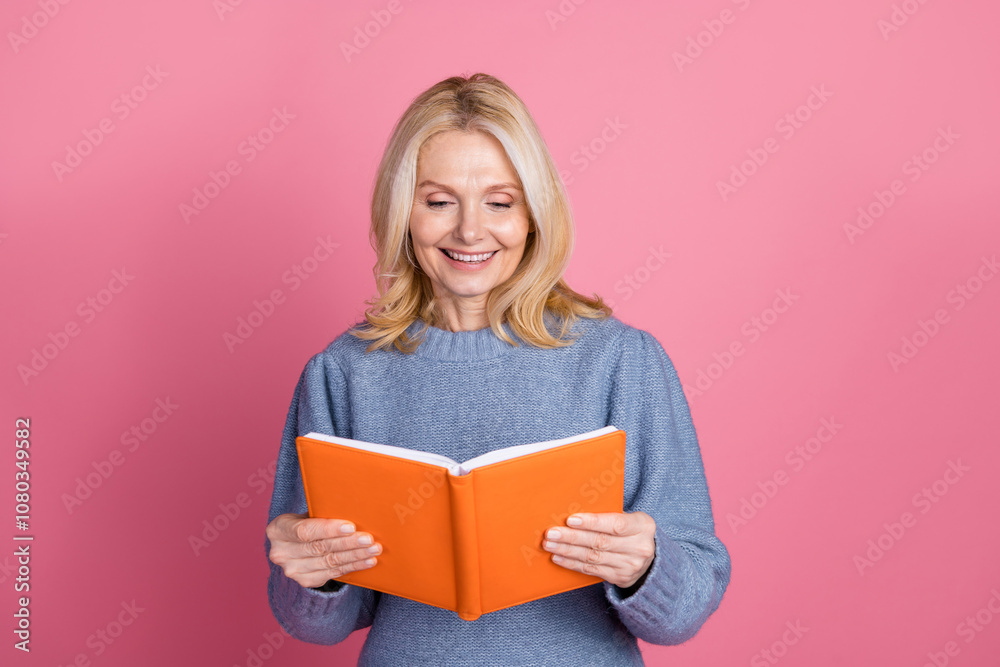 Photo portrait of attractive senior woman reading interesting book dressed stylish blue knitted clothes isolated on pink color background Photo portrait of attractive senior woman reading interesting book dressed stylish blue knitted clothes isolated on pink color background