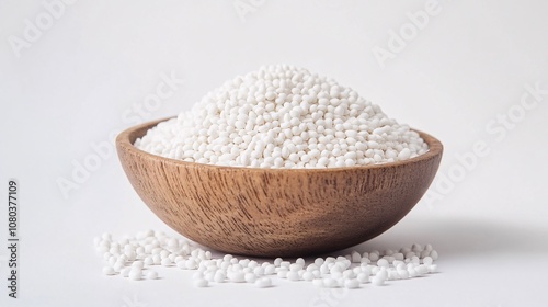 Close-up of white sago pearls in a wooden bowl, showcasing texture and culinary potential. Ideal for food blogs, health websites, or recipe articles.