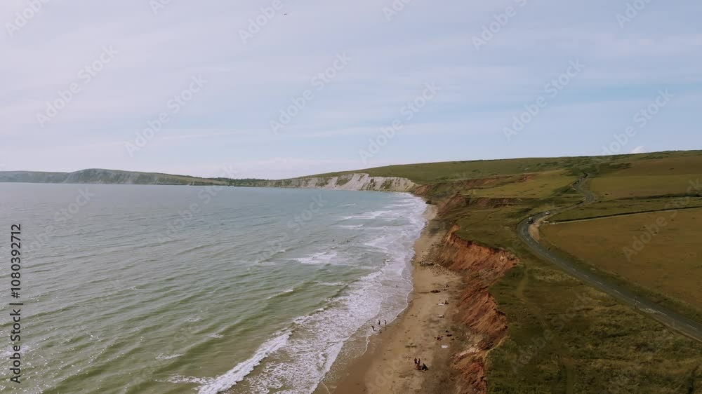 A beautiful beach with a rocky shoreline and a calm ocean. The sky is cloudy, but the beach is still a peaceful place to relax A beautiful beach with a rocky shoreline and a calm ocean. The sky is cloudy, but the beach is still a peaceful place to relax