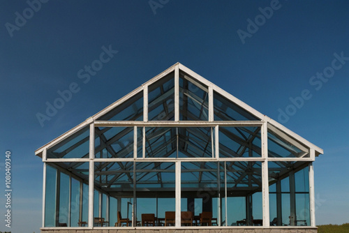 Glass house and blue sky with sun