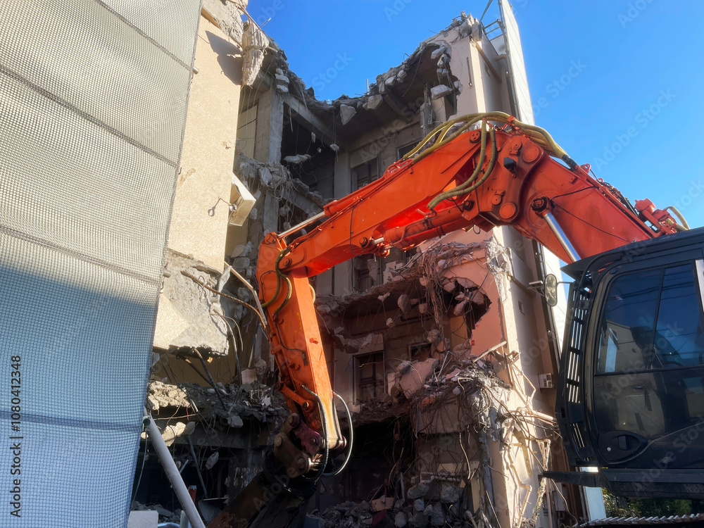 An excavator destroys a residential building An excavator destroys a residential building