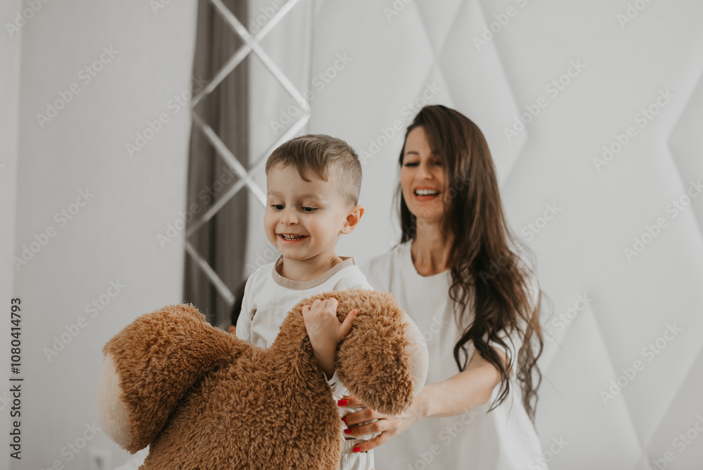 Boy and mother playing with a teddy bear Boy and mother playing with a teddy bear