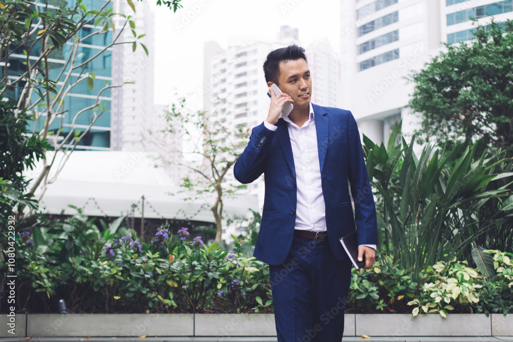Handsome worker in formal wear talking on phone walking outdoors Handsome worker in formal wear talking on phone walking outdoors
