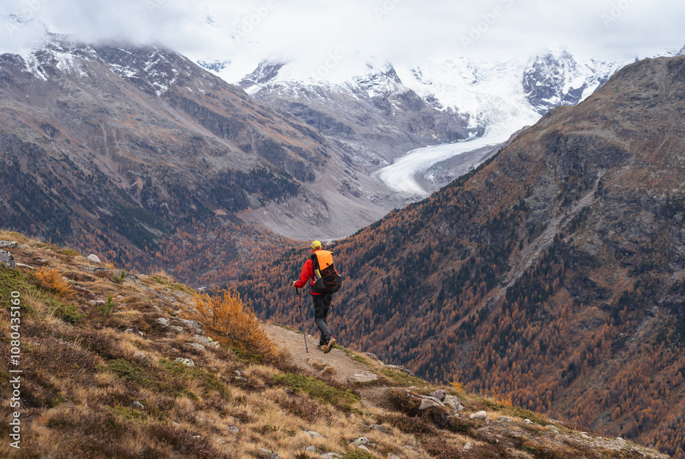 A man hiking in the mountains above Pontresina, in autumn.