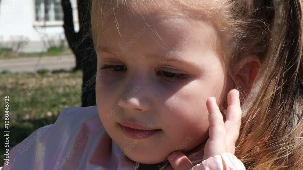 Pretty child girl looking sad, thinking about something. Close up portrait. Outdoors. Walking, thoughtfulness, loneliness. Springtime