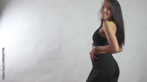 Beautiful model posing in black leggings in front of a white background