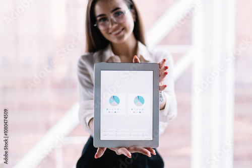 Happy employee demonstrating graphs on screen of tablet photo