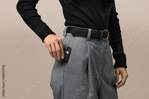 Foto female hand putting black premium credit bank card in pants pocket