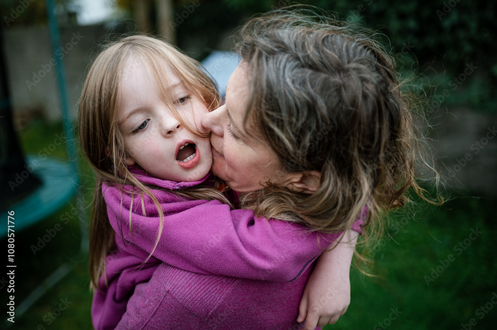 Mother and Daughter Hugging Outside In Their Garden Mother and Daughter Hugging Outside In Their Garden