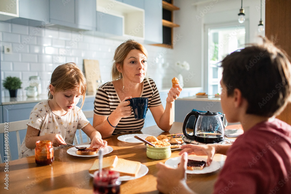 Mother and children enjoying breakfast together in kitchen Mother and children enjoying breakfast together in kitchen