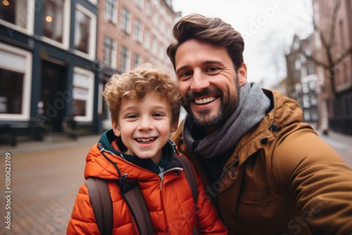 Close up of a father and his son taking selfie while walking in the city