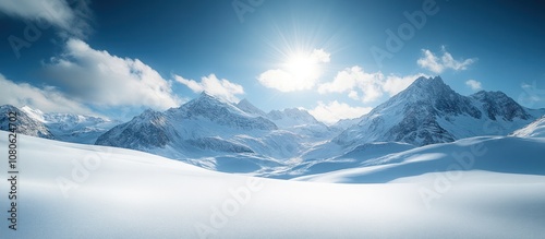 A snowy mountain range with a bright blue sky and sun shining down.