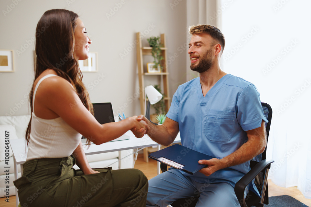 Fototapeta premium Doctor shaking hands with patient after successful medical examination in hospital office