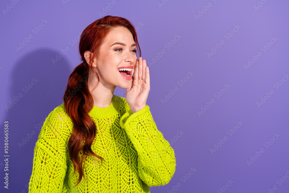 Young red-haired woman excitedly gesturing over vibrant purple background in green knit sweater for promotion concept Young red-haired woman excitedly gesturing over vibrant purple background in green knit sweater for promotion concept