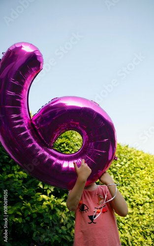 Girl holding a foil number 6 balloon, birthdaygirl