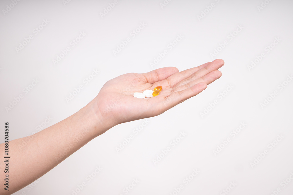 Woman hands taking multiple pills , vitamins D3 and Zinc, daily supplement vitamins isolated on white background Woman hands taking multiple pills , vitamins D3 and Zinc, daily supplement vitamins isolated on white background