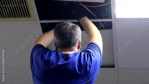 Electrician Installing Overhead Wiring Under Ceiling - Professional Electrical Work and Wiring Installation Process