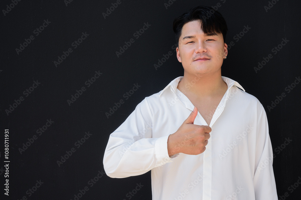Portrait of Handsome Young Asian Man Against Black Background