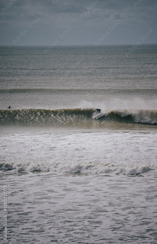 Fototapeta premium Person surfing on a huge wave