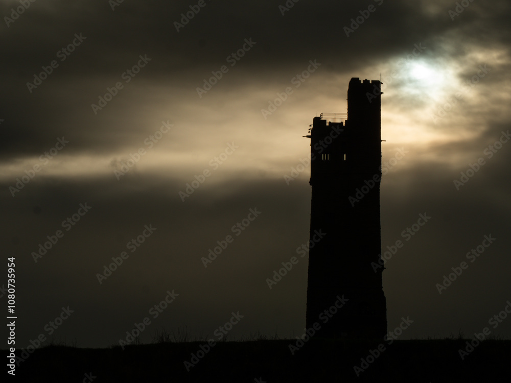 Castle Hill tower in Huddersfield silhouette against storm clouds Castle Hill tower in Huddersfield silhouette against storm clouds