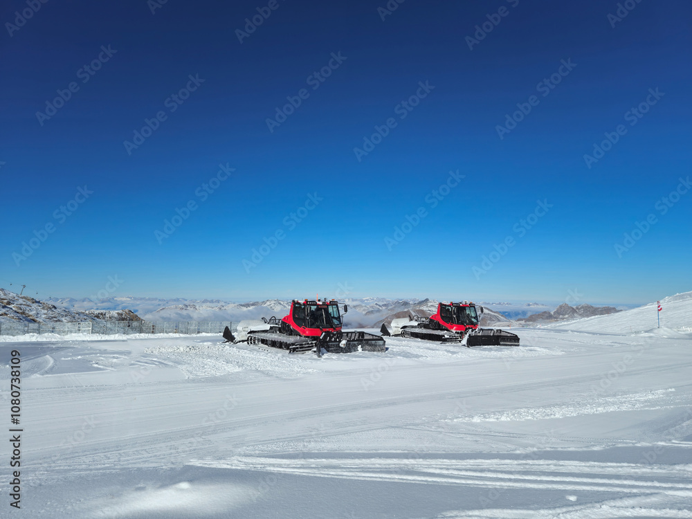 Snow machines on a ski resort. Sunny day snow covered mountains. Snow machines on a ski resort. Sunny day snow covered mountains.