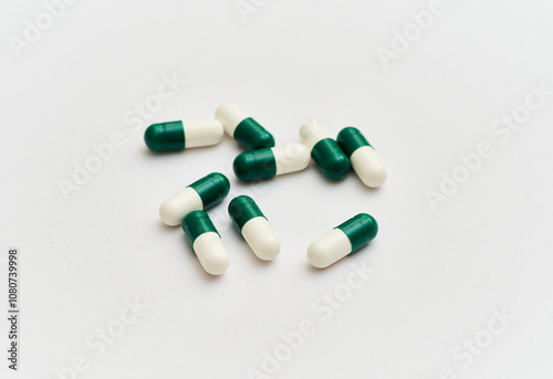 White and green pills on a white background centered