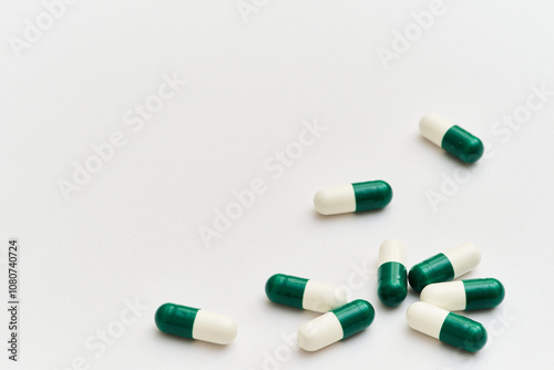 White and green pills on white background bottom right