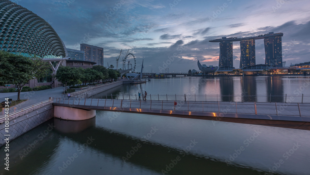 Skyline in Marina Bay with Esplanade Theaters on the Bay and Esplanade footbridge night to day timelapse in Singapore. Skyline in Marina Bay with Esplanade Theaters on the Bay and Esplanade footbridge night to day timelapse in Singapore.